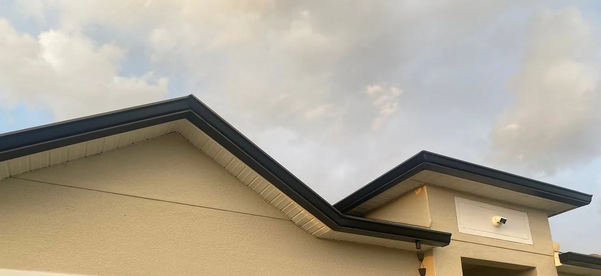 Dark gutters along the edges of a beige gabled facade.